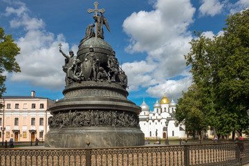 Fototapeta na wymiar VELIKY NOVGOROD, RUSSIA - AUGUST 14, 2018: Monument Millenium of Russia on the background of St. Sophia Cathedral with tourists walking along in summer day