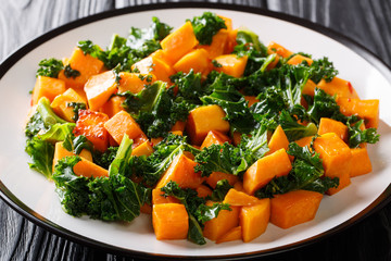Healthy eating fried sweet potatoes with cabbage kale close up on a plate. horizontal