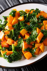 Organic sweet potato with kale cabbage close-up on a plate. vertical