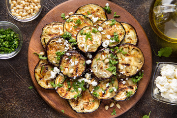 Fried eggplant with feta, pine nuts, fresh herbs (cilantro, parsley) and olive oil. Tasty vegetable...