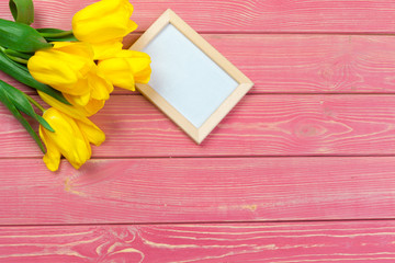 easter, holidays, tradition and object concept - close up of colored eggs and tulip flowers over wooden boards background