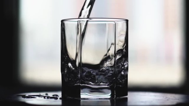Water pour into a glass. Slow motion