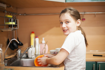 Obraz na płótnie Canvas girl washing dishes in kitchen sink.
