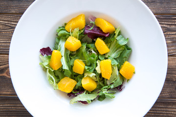 Tasty pumpkin salad on brown table, top view.