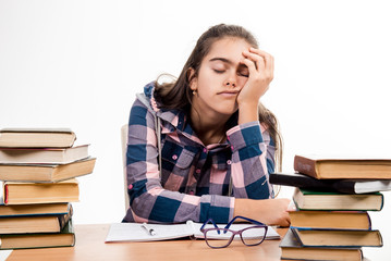 Exams at school. Education. Tired eyes from reading. Printed books, study at school. Library. Girl with books. student is sitting at the table with books. Learning fatigue.