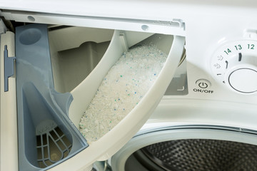 Detergent in the washing machine in laundromat. Concept- detergent dosage, housework, house cleaning.