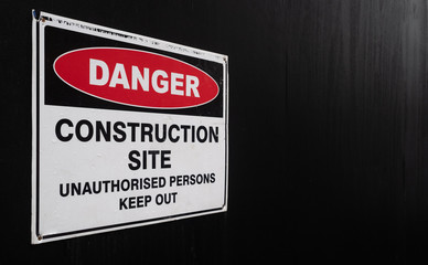 Construction Site Danger Sign Against Black Fence