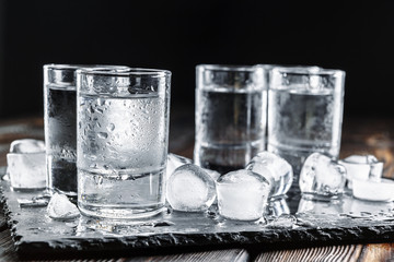 Vodka in shot glasses on rustic wood background