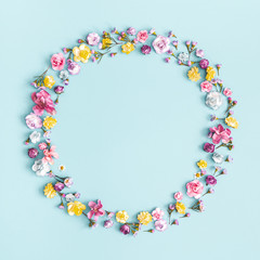 Flowers composition. Wreath made of colorful flowers on pastel blue background. Spring, easter,...