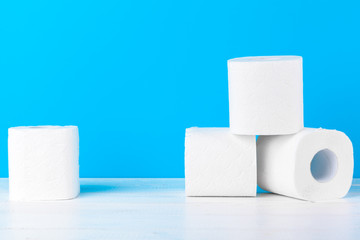 Toilet paper rolls stacked against blue background