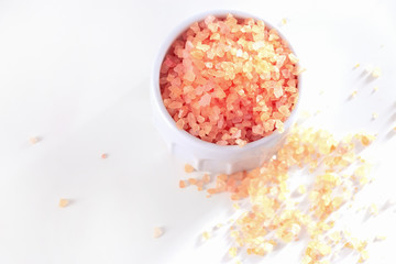 Big Crystals of pink Himalayan salt in jar. White background. Top view.