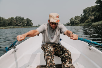 man with beard rowing on rowing boat © glebchik