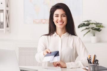 Female travel agent holding passport with tickets