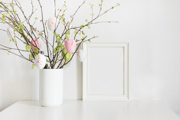 Fototapeta na wymiar Easter. Vase with birch tree branches with Easter eggs and frame.