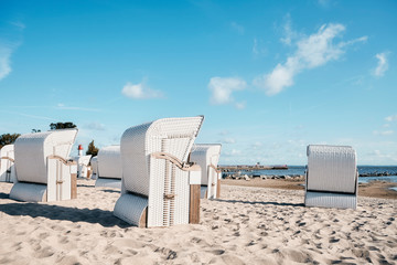 Obraz na płótnie Canvas Wicker beach chairs on empty sandy beach, color toning applied.