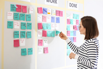 Young woman near scrum task board in office
