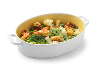 Casserole with tasty corn cobs and vegetables on white background
