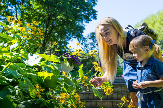 Cute blonde woman and her daughter in the park