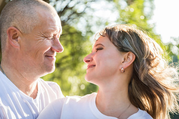 Adult couple loving each other in the Park on a Sunny day. Ordinary full man and full woman hug each other