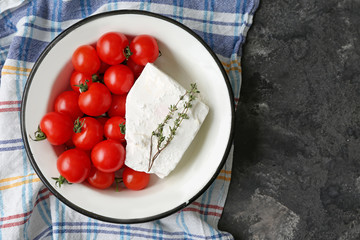 Bowl with tasty feta cheese and tomatoes on grey background