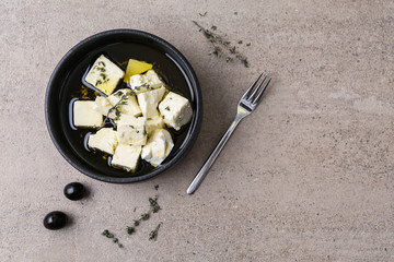 Plate with tasty feta cheese, thyme and olive oil on grey table