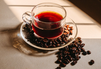 Clear glass, put coffee with coffee beans placed on the table Light sunlight that passes through the window in the morning