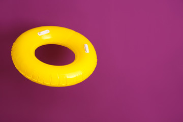 Bright inflatable ring on color background