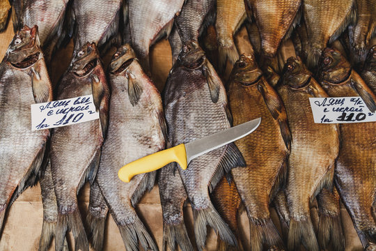 Several dried bream fish are lying on counter