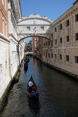 Fototapeta na wymiar View of one of little canals with gondolas and historical buildings in Venice, Italy 