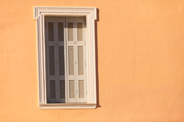 Fototapeta na wymiar Old window shutters on orange home