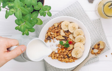 Granola in the bowl on white wooden background