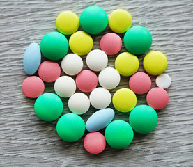A lot of multi-colored tablets of different shapes. Pills are used in medicine to heal people.
