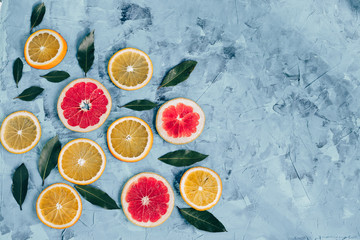 The composition of orange slices and grapefruit on a gray table top view