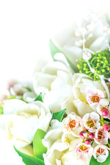 Beautiful bouquet of white tulips with green leaves and other decorative flowers close up.