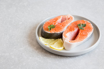 fresh fish. fresh salmon steaks with lemon in a light plate