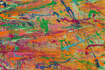 bright multi-colored spots and splashes of paint on a concrete wall