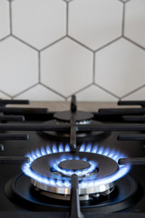 Gas burner on black modern kitchen stove. kitchen gas cooker with burning fire propane gas.