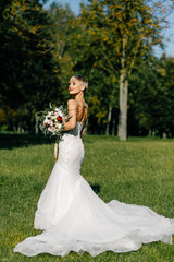 Fototapeta na wymiar fashionable bride with short hair posing in the park