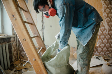 Worker cleans the trash in the apartment in the bag