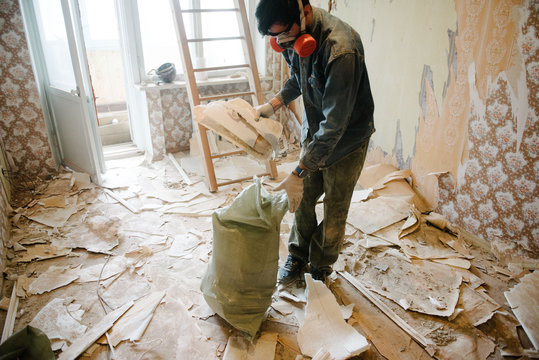 Worker cleans the trash in the apartment in the bag