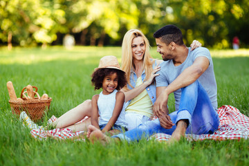 Fototapeta premium Picture of lovely couple with their daughter having picnic