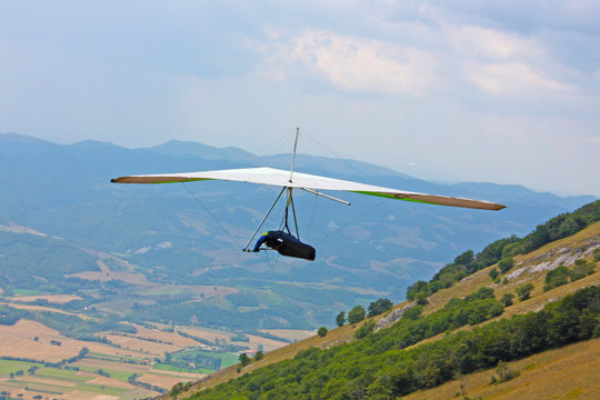 Hang glider pilot in Italian mountains