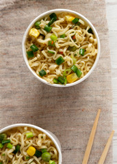 Tasty instant ramen noodles with beef flavoring in paper cups. Flat lay, from above, overhead. Close-up.