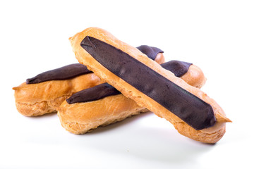 Fresh eclairs with dark chocolate with custard inside on a white background.