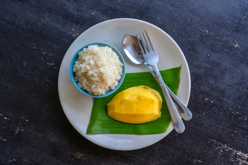 Thai style dessert, mango with sticky rice on plate. Yellow mango and sticky rice is popular traditional dessert of Thailand
