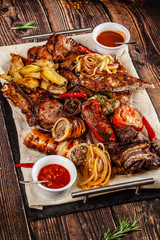 Concept of Georgian cuisine. Large meat board with shashlik, roasted meat, french fries, roast lamb and sauce. Serving dishes in a restaurant on a pita. Top view, copy space