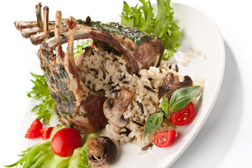 roasted lamb ribs crown on a plate with rice and mushrooms