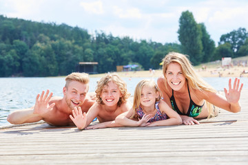 Familie mit zwei Kindern auf einem Steg am See
