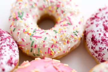 sweet food, junk-food and unhealthy eating concept - close up of glazed donuts on white table
