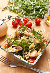 Serving of pasta salad with chicken, mushrooms, rucola  and cherry tomatoes